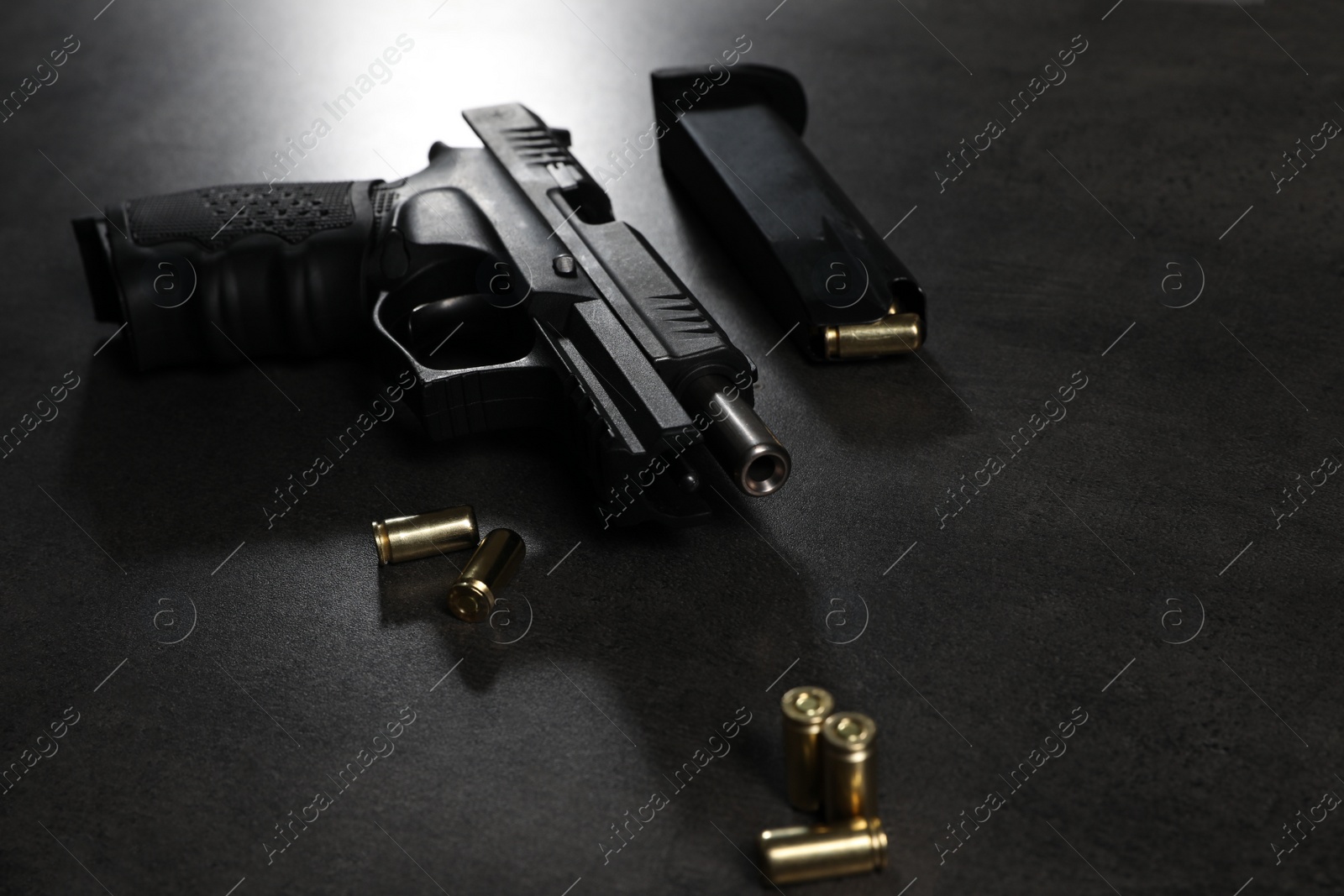 Photo of Handgun, magazine and bullets on grey table