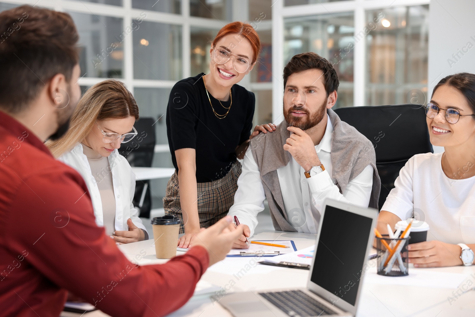 Photo of Team of employees working together in office