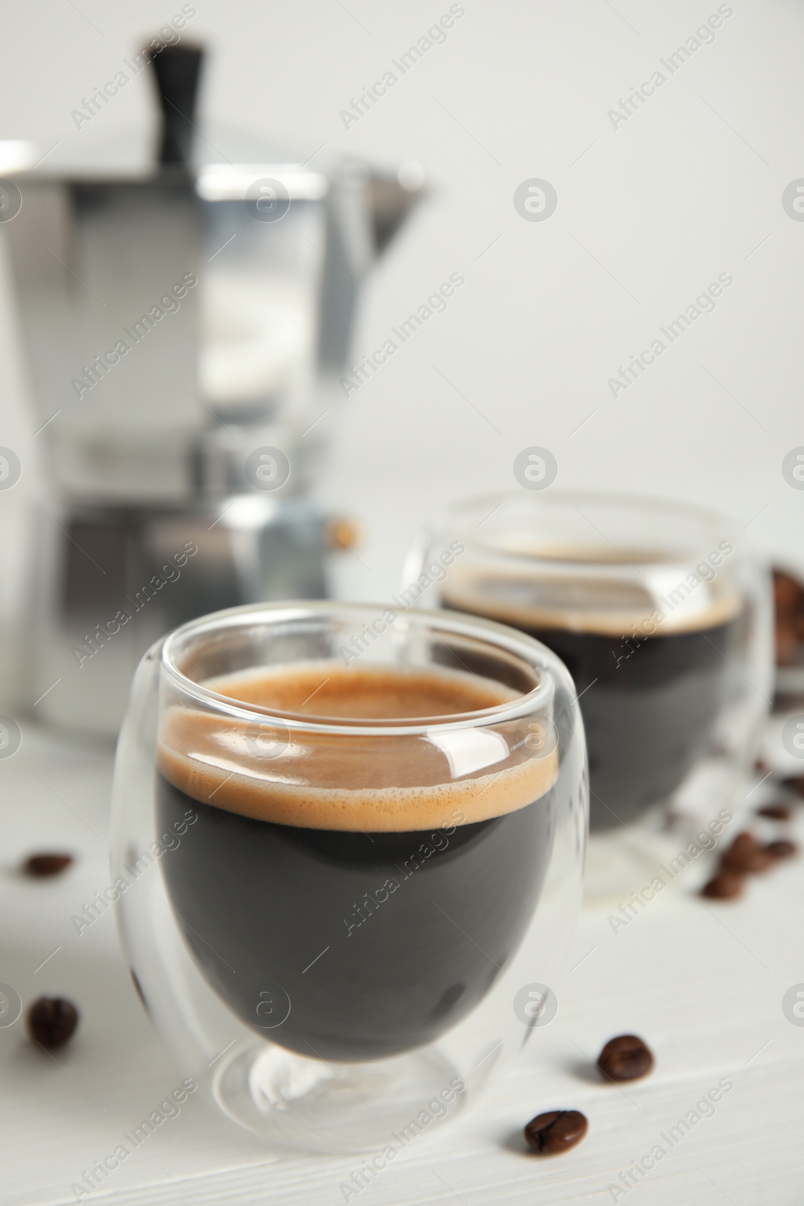 Photo of Tasty coffee and beans on white wooden table