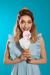 Portrait of young woman holding cotton candy dessert on blue background