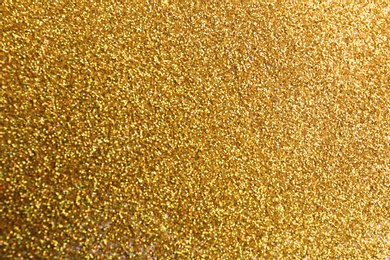 Photo of Closeup view of sparkling golden glitter background