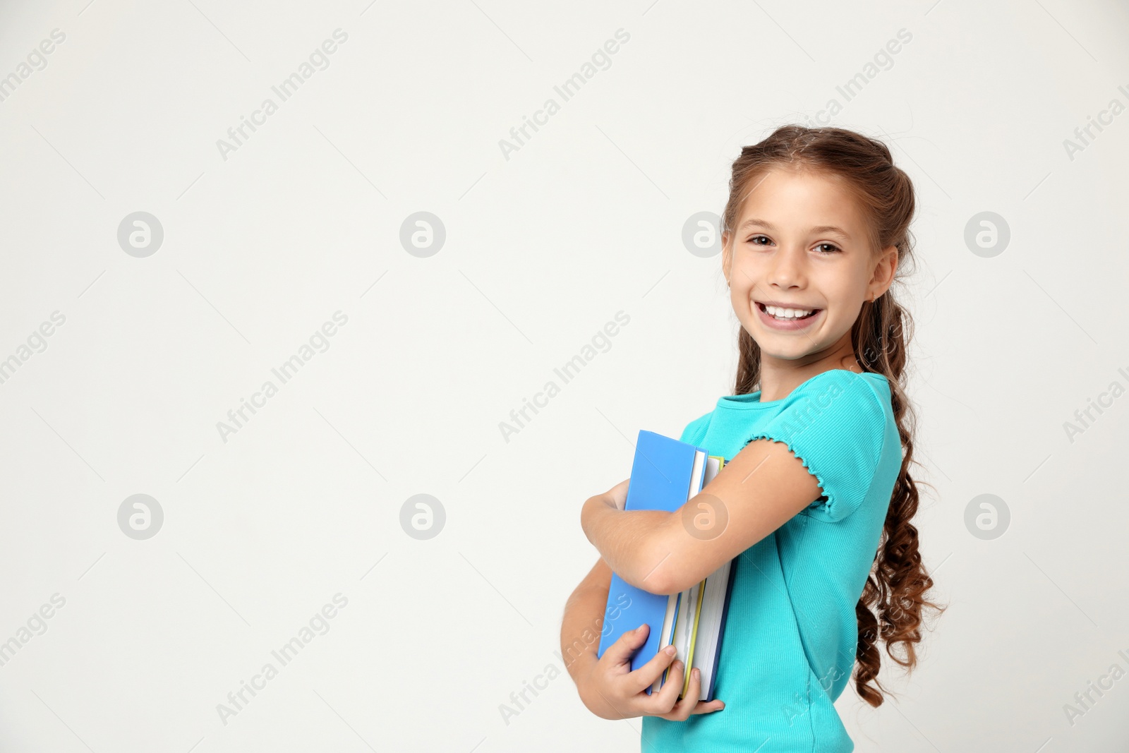 Photo of Portrait of cute little girl with books on grey background, space for text. Reading concept