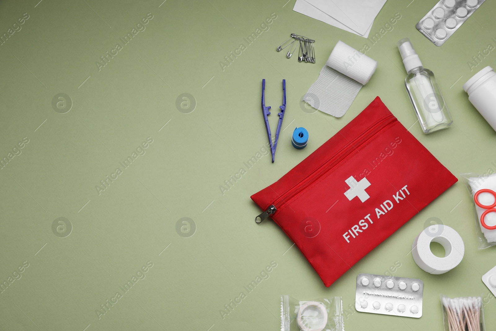 Photo of Flat lay composition with first aid kit on light green background, space for text