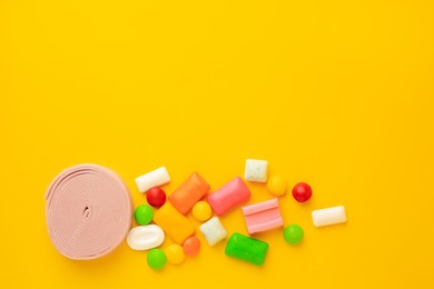 Many different chewing gums on yellow background, flat lay. Space for text