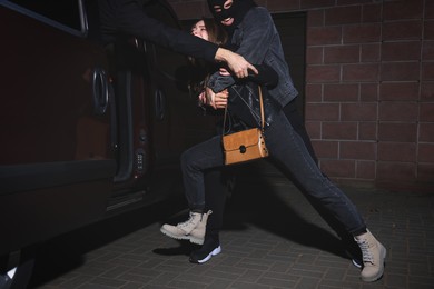 Photo of Criminals kidnapping young woman at night. Self defense concept