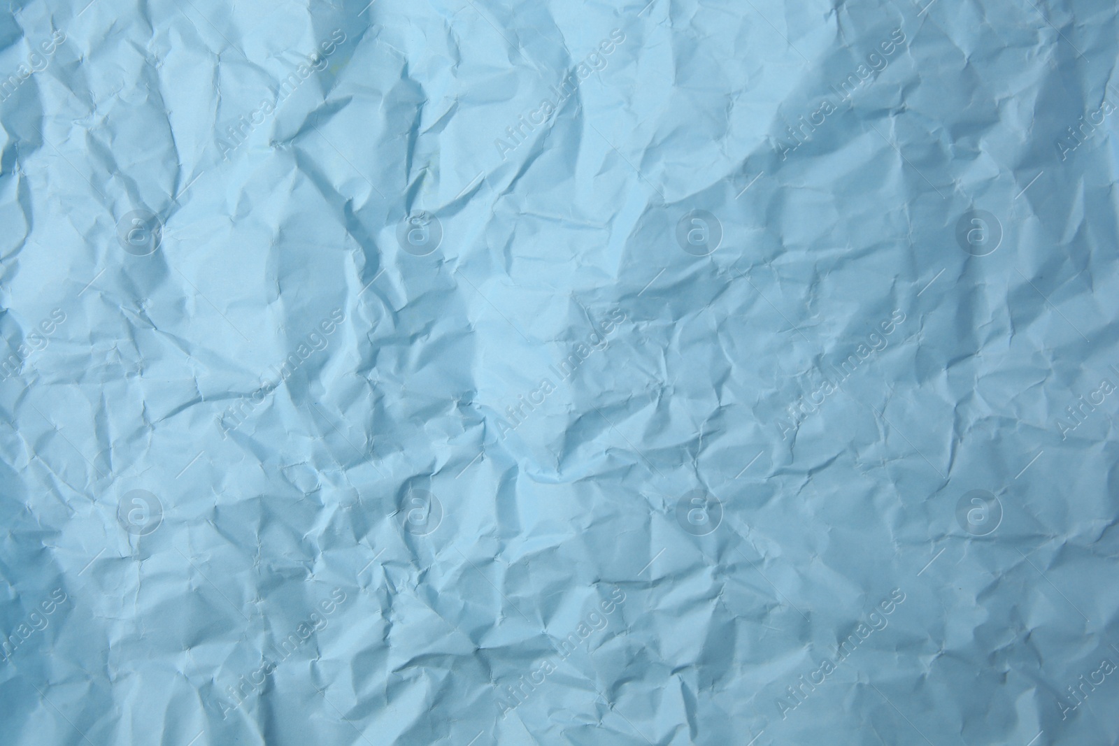 Photo of Sheet of crumpled light blue paper as background, top view