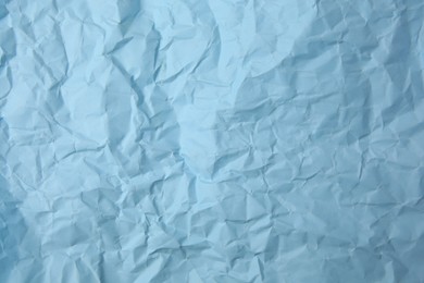 Sheet of crumpled light blue paper as background, top view