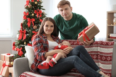 Photo of Happy couple with baby celebrating Christmas together at home