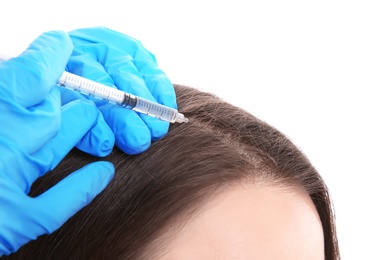 Photo of Young woman with hair loss problem receiving injection on white background