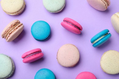 Photo of Delicious colorful macarons on violet background, flat lay