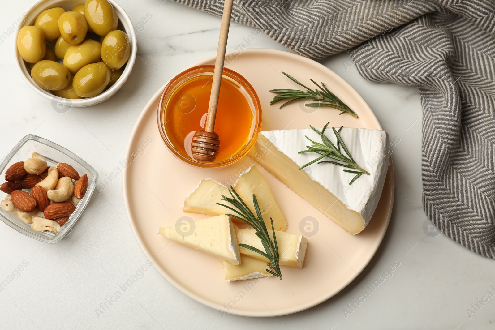 Photo of Tasty Camembert cheese with rosemary and honey on white table, flat lay