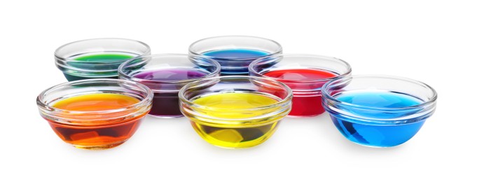 Photo of Glass bowls with different food coloring on white background