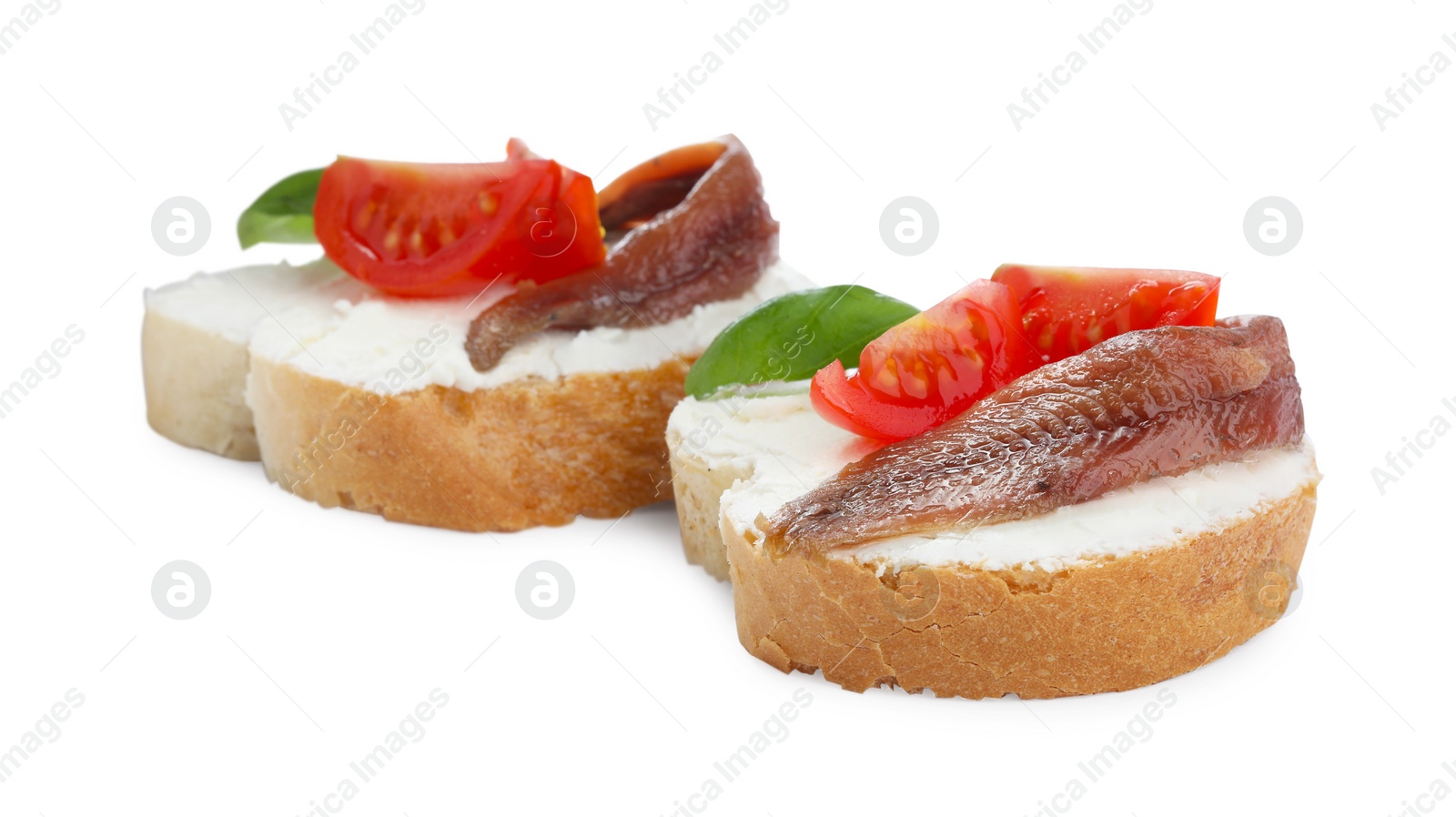 Photo of Delicious sandwiches with cream cheese, anchovies, tomatoes and basil on white background