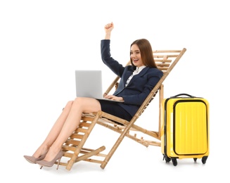 Photo of Young businesswoman with laptop and suitcase on sun lounger against white background. Beach accessories