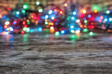 Wooden table and blurred Christmas lights on background