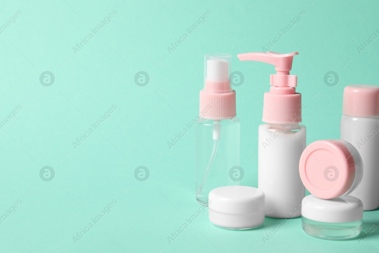 Photo of Cosmetic travel kit on turquoise background. Space for text