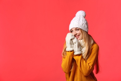 Photo of Portrait of emotional young woman in stylish clothes on color background, space for text. Winter atmosphere