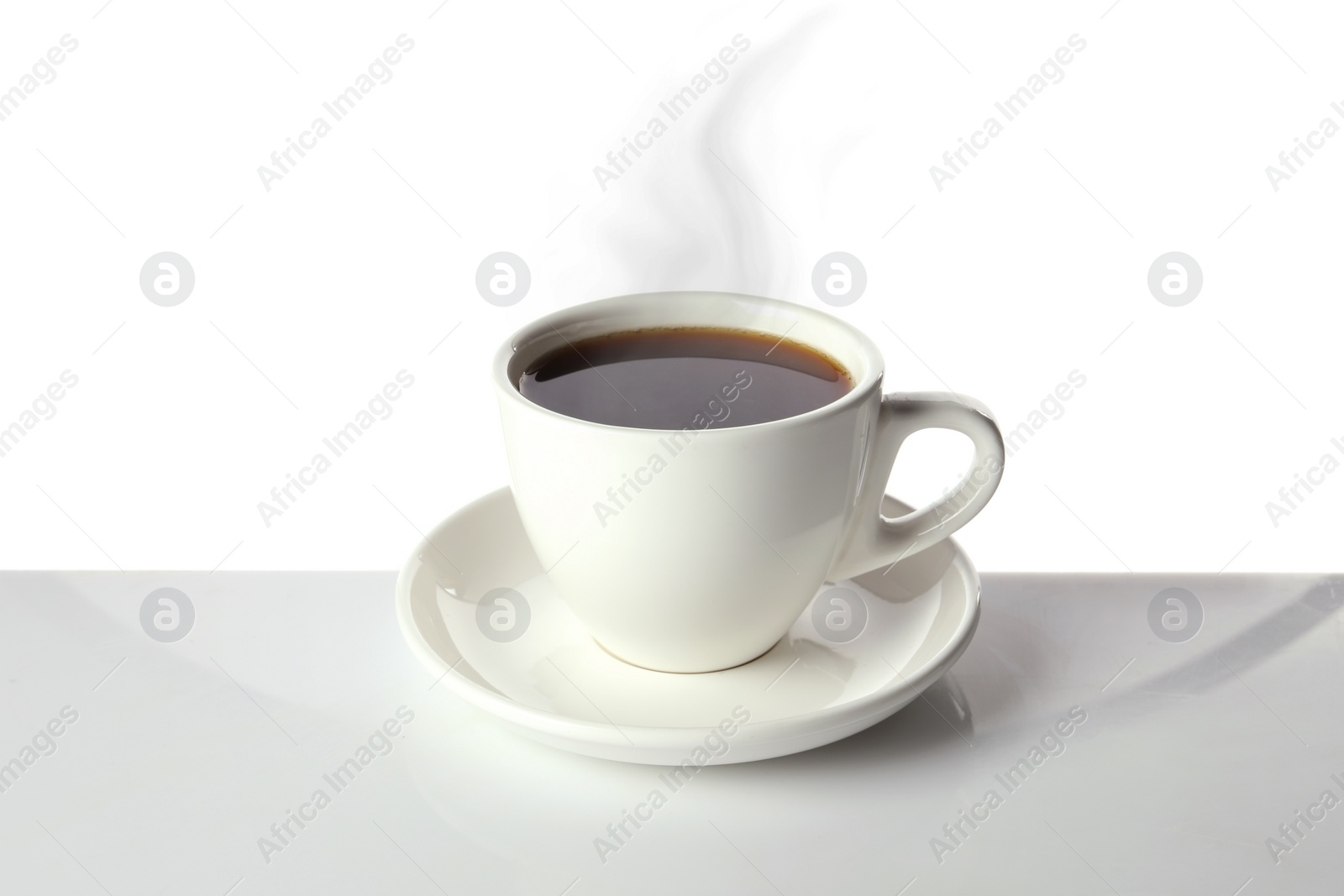 Image of Steaming coffee in cup on table against white background