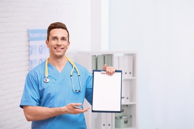 Portrait of medical assistant with stethoscope and clipboard in hospital. Space for text