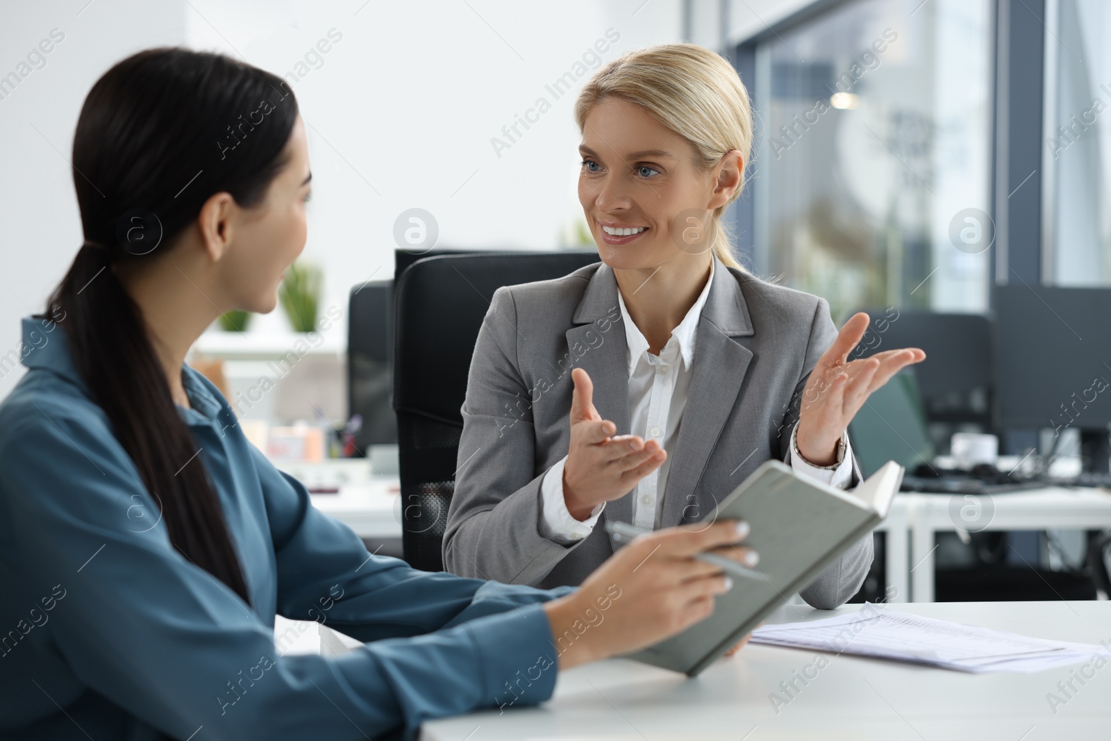 Photo of Lawyers with notebook working together at table in office