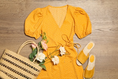 Flat lay composition with stylish yellow dress on wooden background