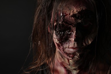 Photo of Scary zombie on dark background, closeup. Halloween monster