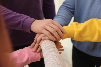 Group of people holding their hands together, closeup