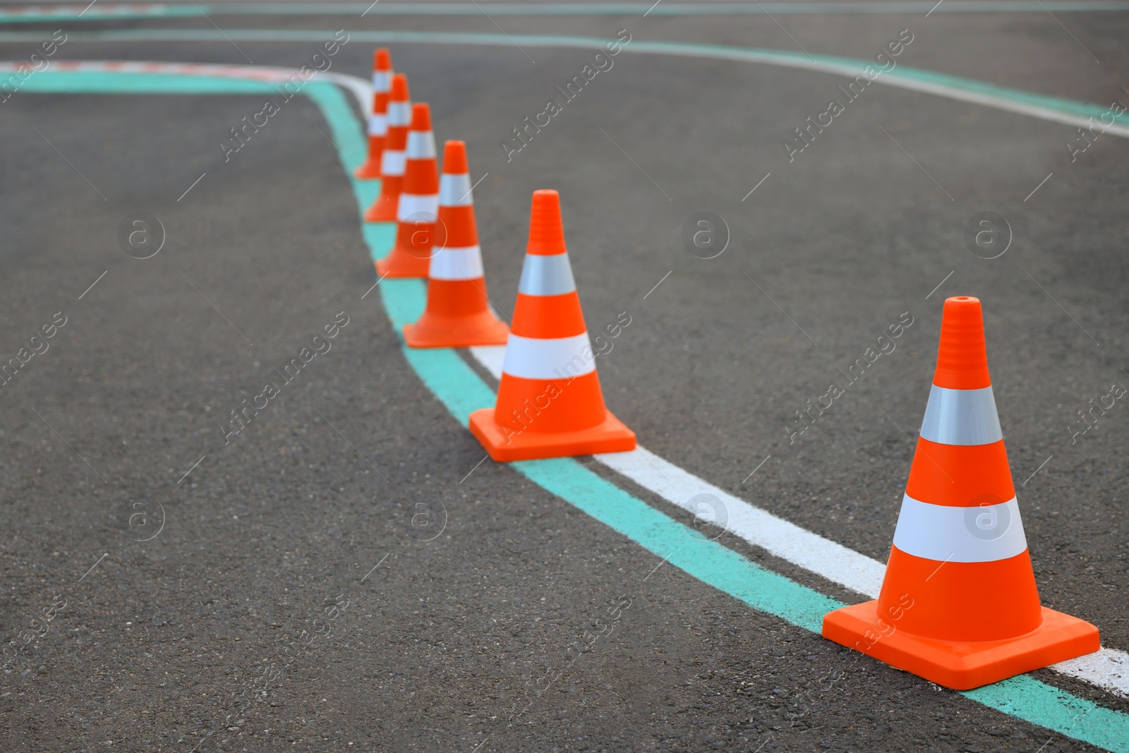 Photo of Driving school test track with marking lines, focus on traffic cone