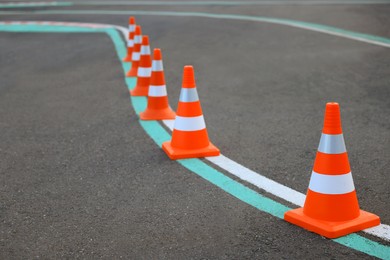 Photo of Driving school test track with marking lines, focus on traffic cone
