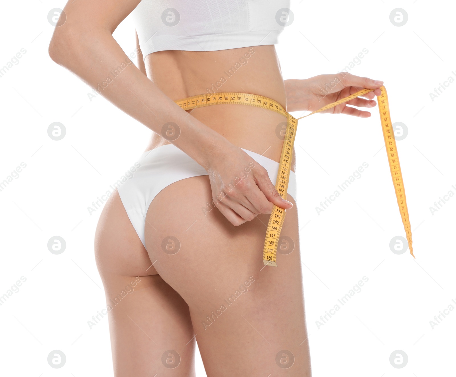 Photo of Slim young woman with smooth gentle skin in underwear measuring body on white background, closeup