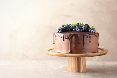 Fresh delicious homemade chocolate cake with berries on table against color background. Space for text