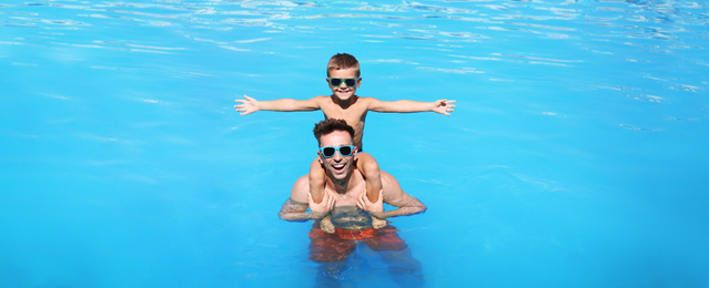 Image of Little boy with father in swimming pool. Banner design