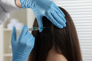 Photo of Trichologist giving injection to patient in clinic, closeup