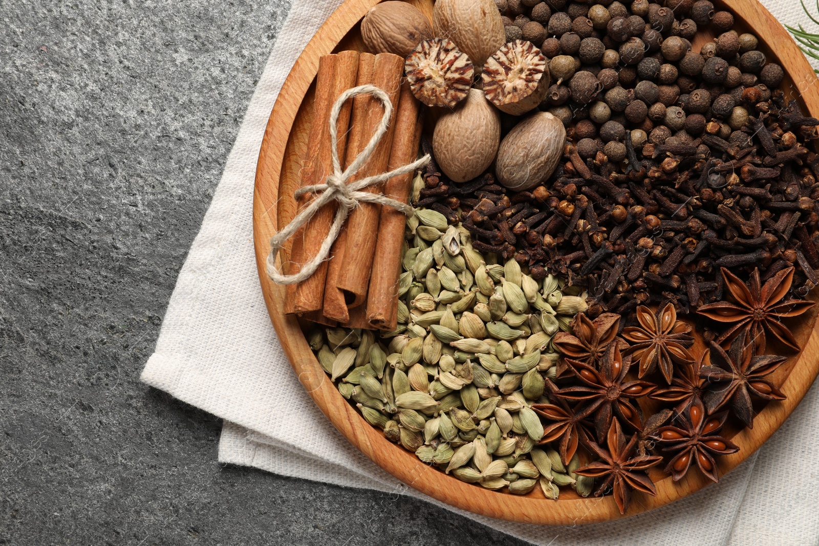 Photo of Different spices and nuts on gray table, top view