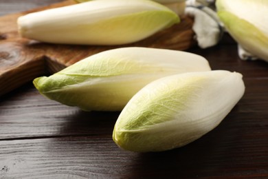 Raw ripe chicories on wooden table, closeup