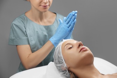 Photo of Young woman visiting cosmetologist in spa salon