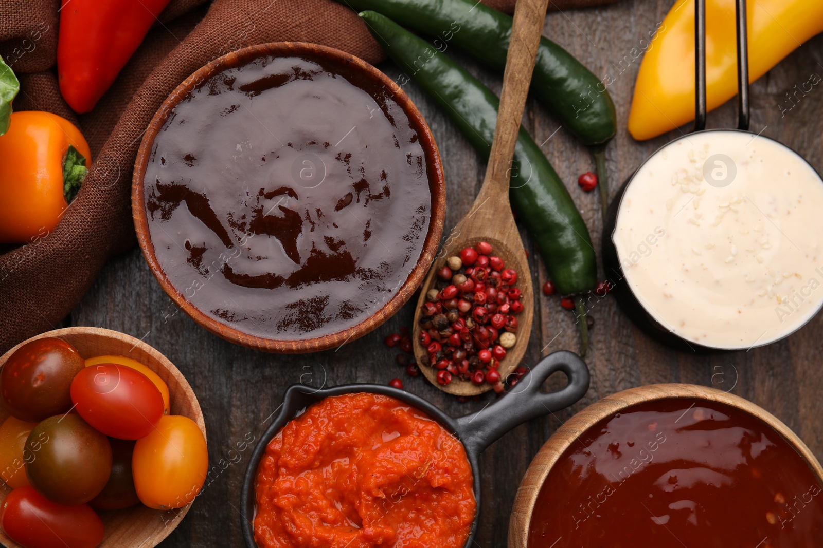 Photo of Different marinades and products on wooden table, flat lay