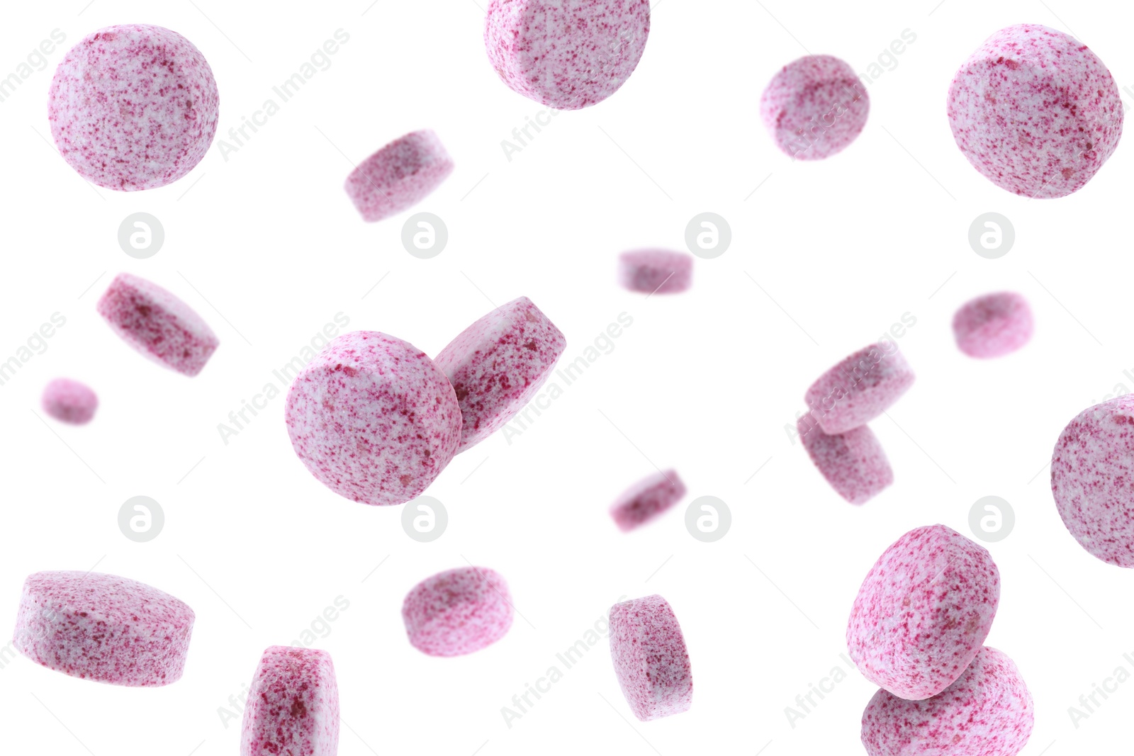 Image of Vitamin. Pink tablets falling on white background