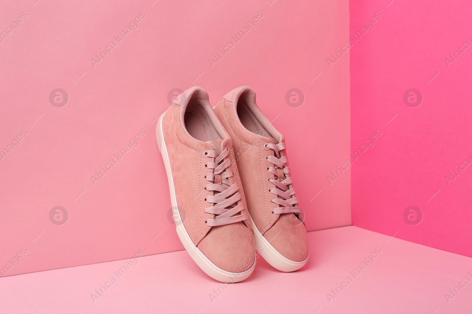 Photo of New comfortable sneakers with laces on color background