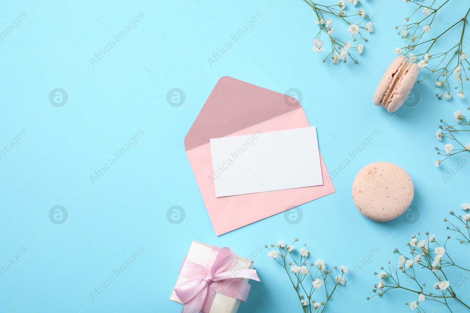 Photo of Flat lay composition with greeting card on light blue background, space for text. Happy Mother's Day