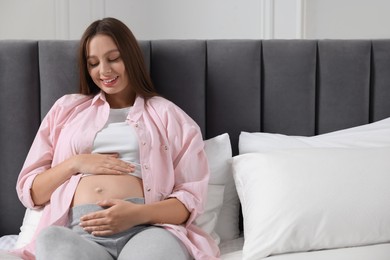 Beautiful pregnant woman with long hair in bedroom