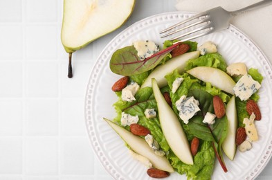 Photo of Delicious pear salad and fruit on white tiled table, top view. Space for text