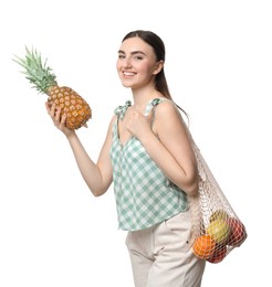 Photo of Woman with string bag of fresh fruits holding pineapple on white background
