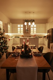 Festive table setting and beautiful Christmas decor in kitchen. Interior design