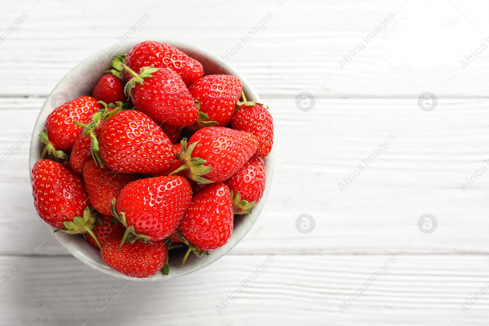 Photo of Bowl with fresh ripe strawberries on wooden background, top view