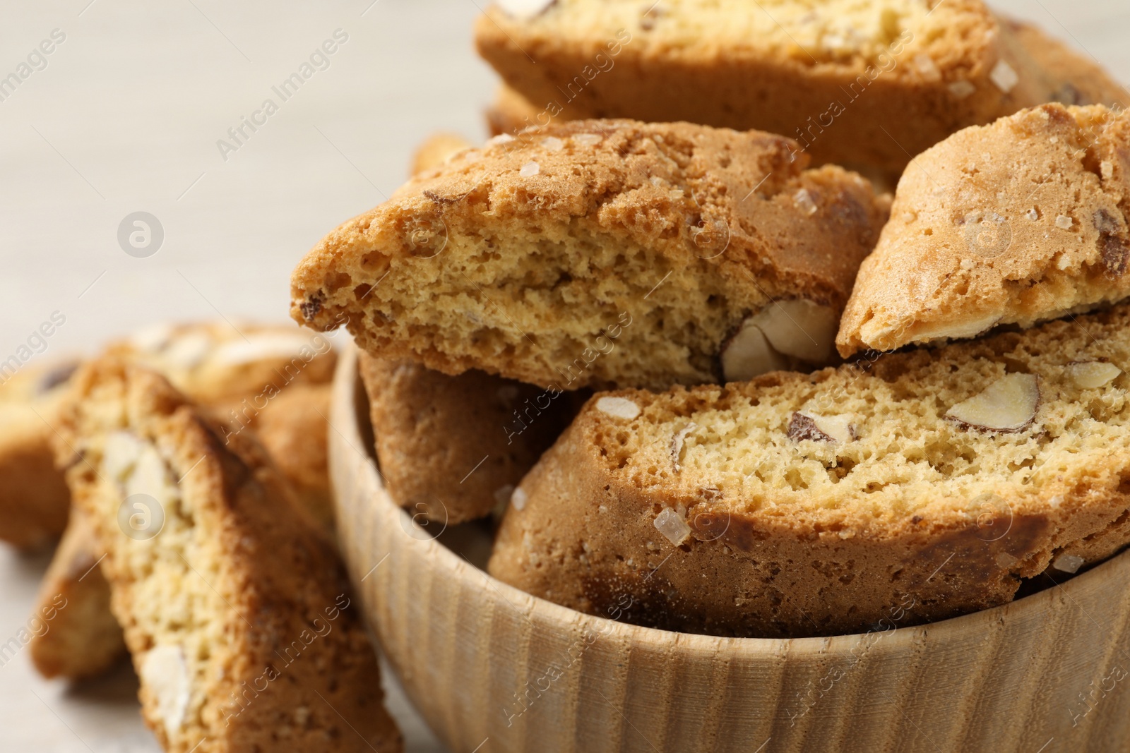 Photo of Traditional Italian almond biscuits (Cantucci) in bowl on table, closeup
