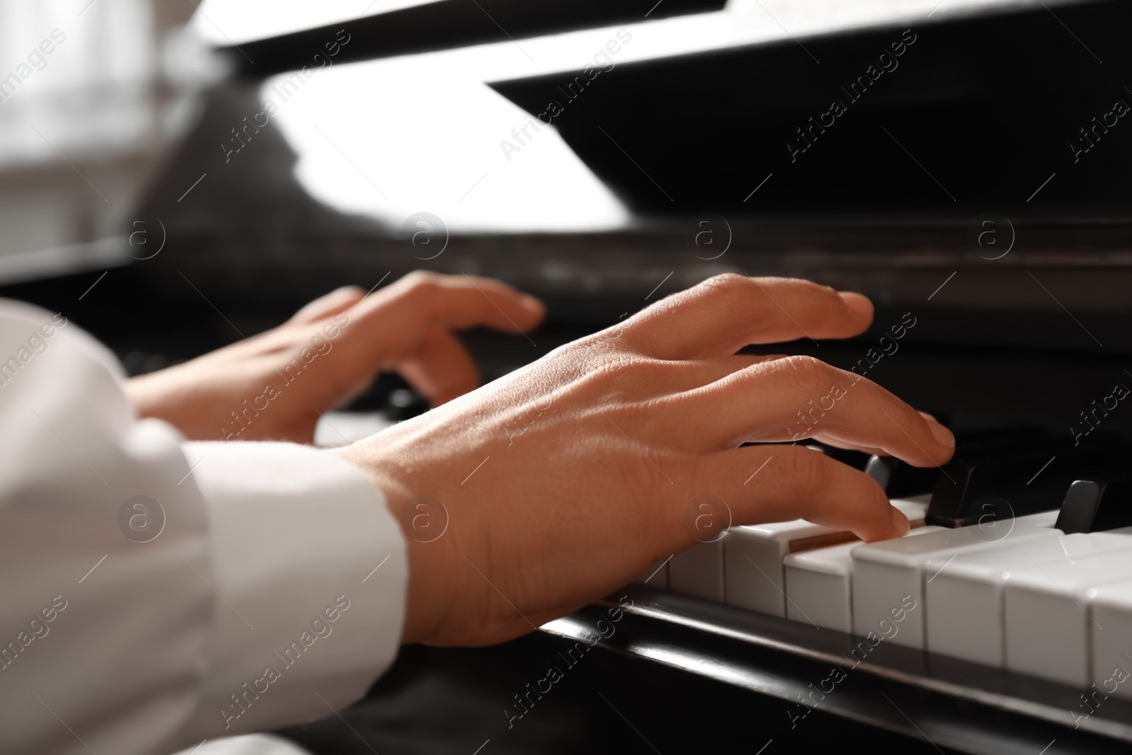 Photo of Young woman playing piano, closeup. Music lesson