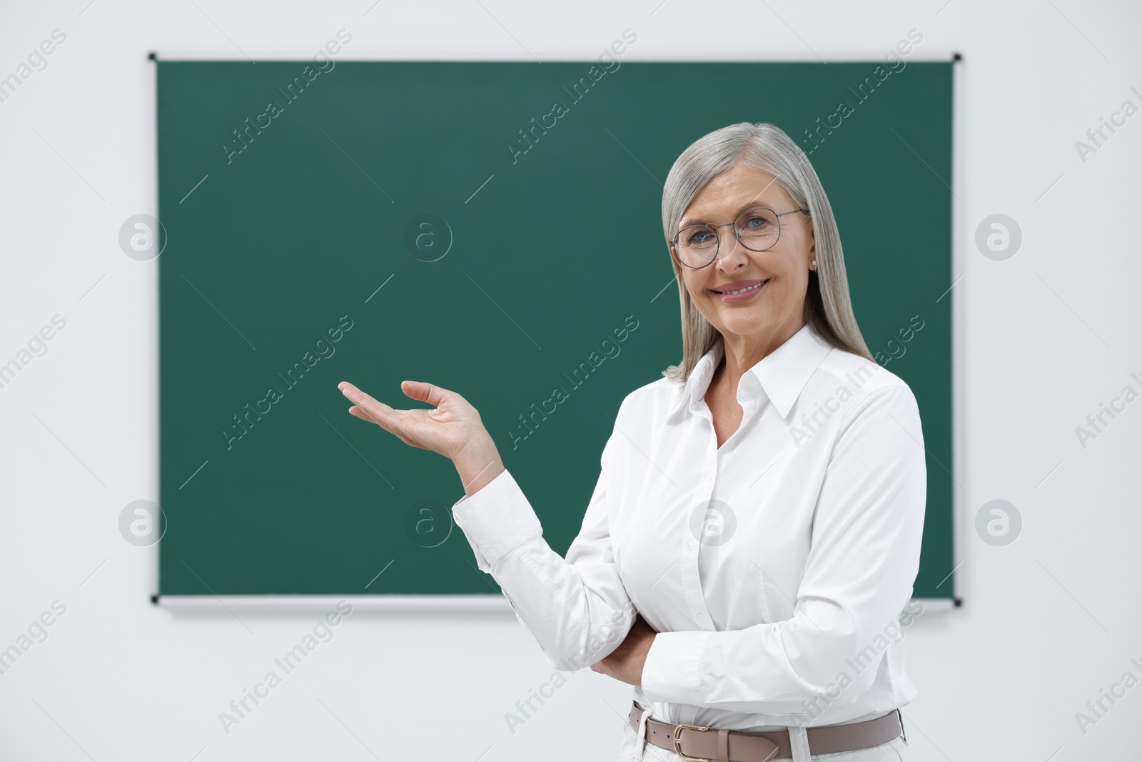 Photo of Portrait of happy professor near blackboard in classroom