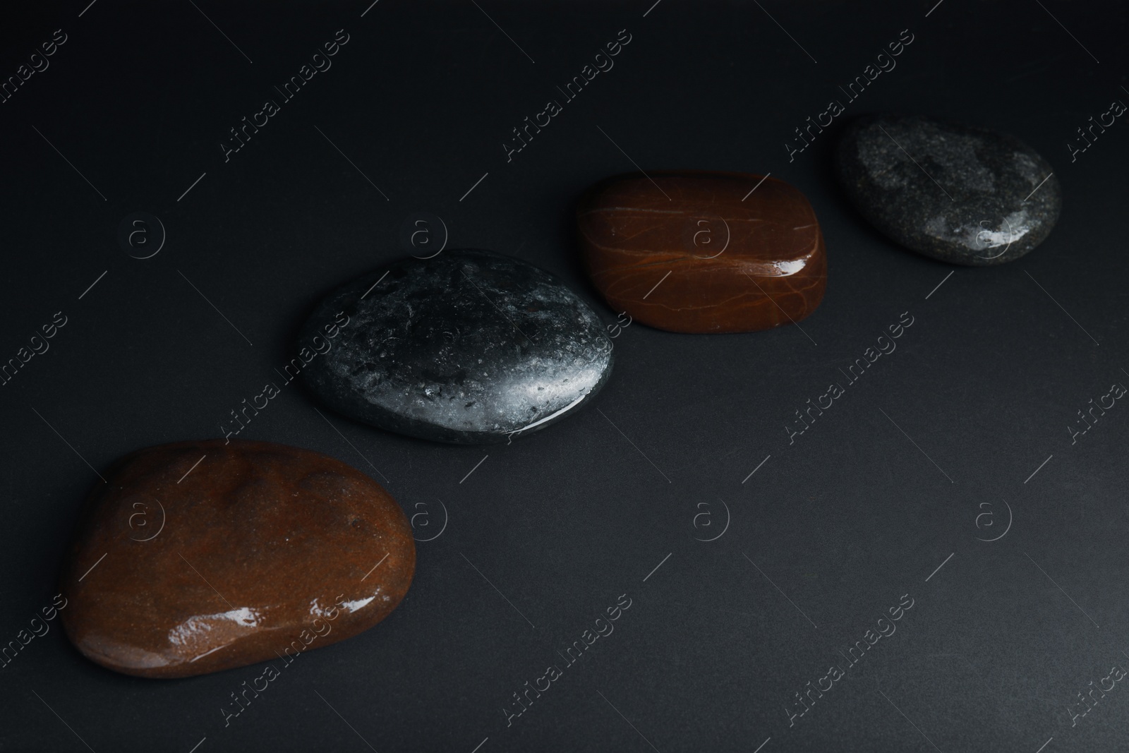 Photo of Stones in water on dark background. Zen lifestyle