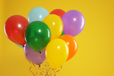 Bunch of bright balloons on color background, space for text. Celebration time